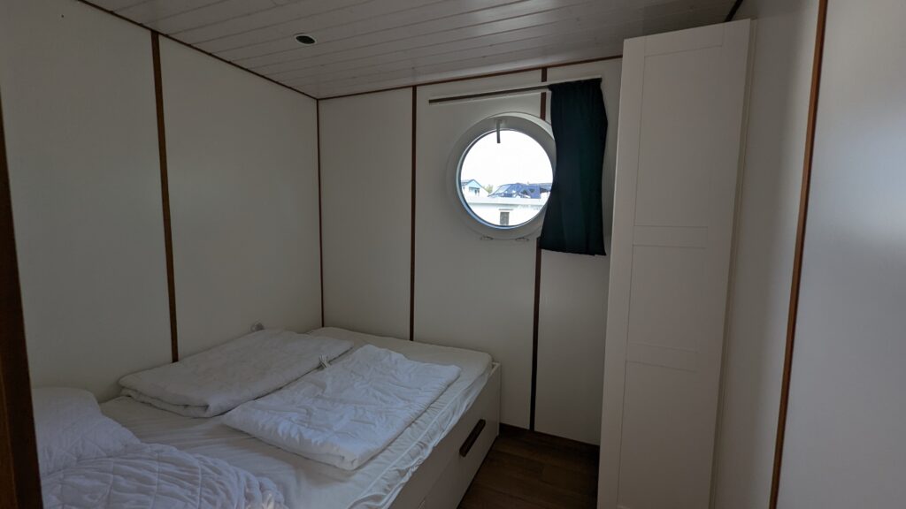 Großes Bett mit einem kleinem Fenster