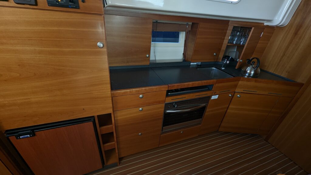 Küche mit Gasherd, Backofen, Kühlschrank und Waschbecken