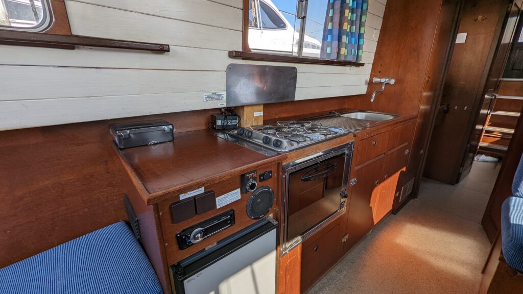 Kochzeile mit Kühlschrank, Gasherd und Spülbecken